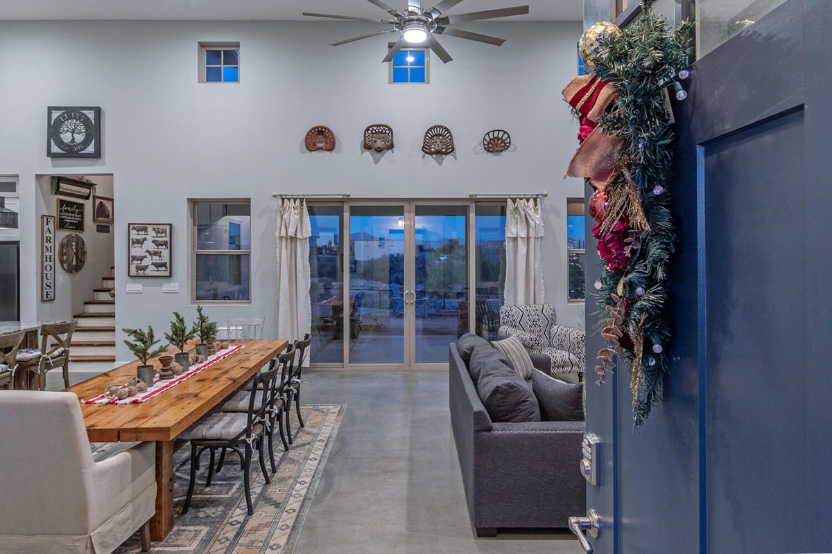 Neutral holiday-themed living room ready for a real estate showing, with subtle Christmas decorations, spacious dining area, and comfortable seating.