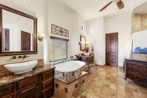 Primary bathroom at 28025 N 156th Place featuring dual vanities, granite counters, soaking tub, and walk-in shower