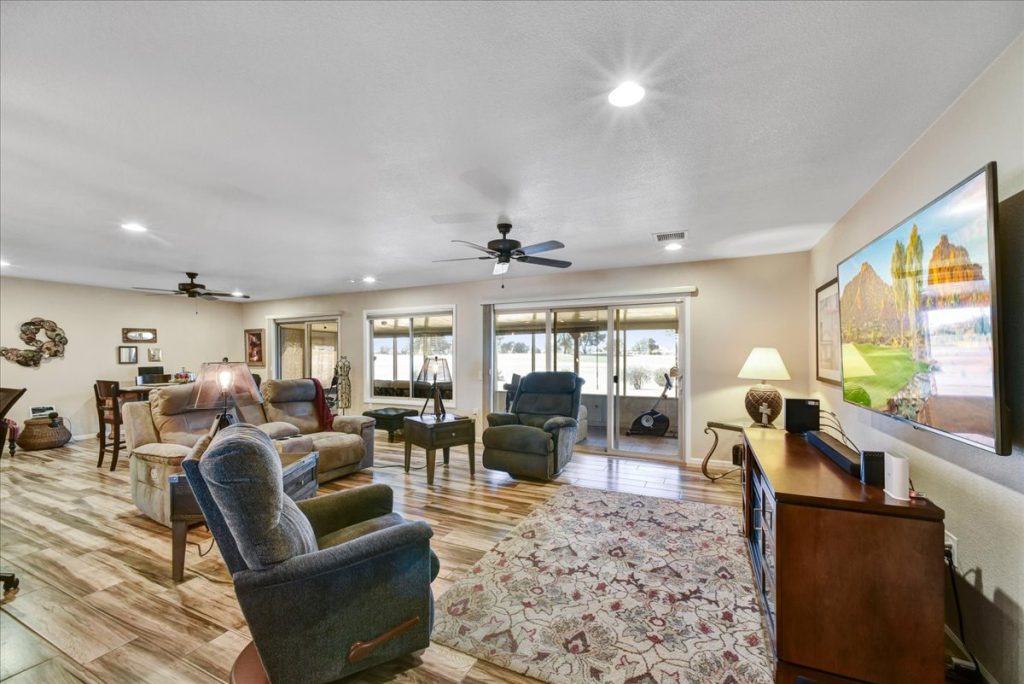 Spacious great room at 18410 N 104th Avenue in Sun City, featuring comfortable furnishings, scenic views, and modern finishes