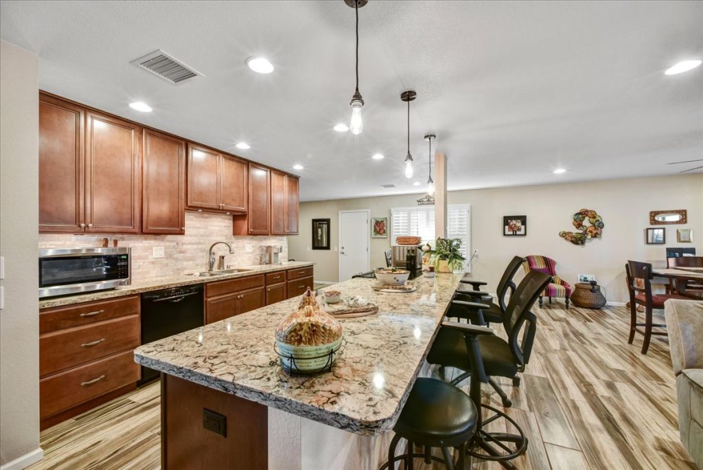 Remodeled kitchen with quartz countertops, stainless steel appliances, and sunset views at 18410 N 104th Avenue, Sun City