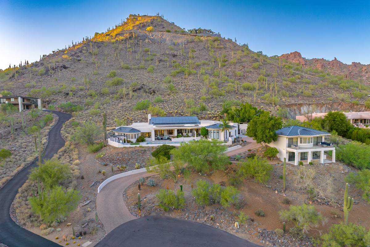 Aerial photo of a luxury home at 6432 E El Sendero Rd in Carefree, Arizona, set against the south face of Black Mountain with a curved driveway and surrounding desert landscape.