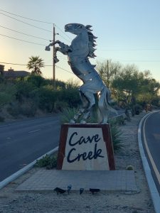 Metal horse statue marking the Cave Creek entrance with desert landscape in the background